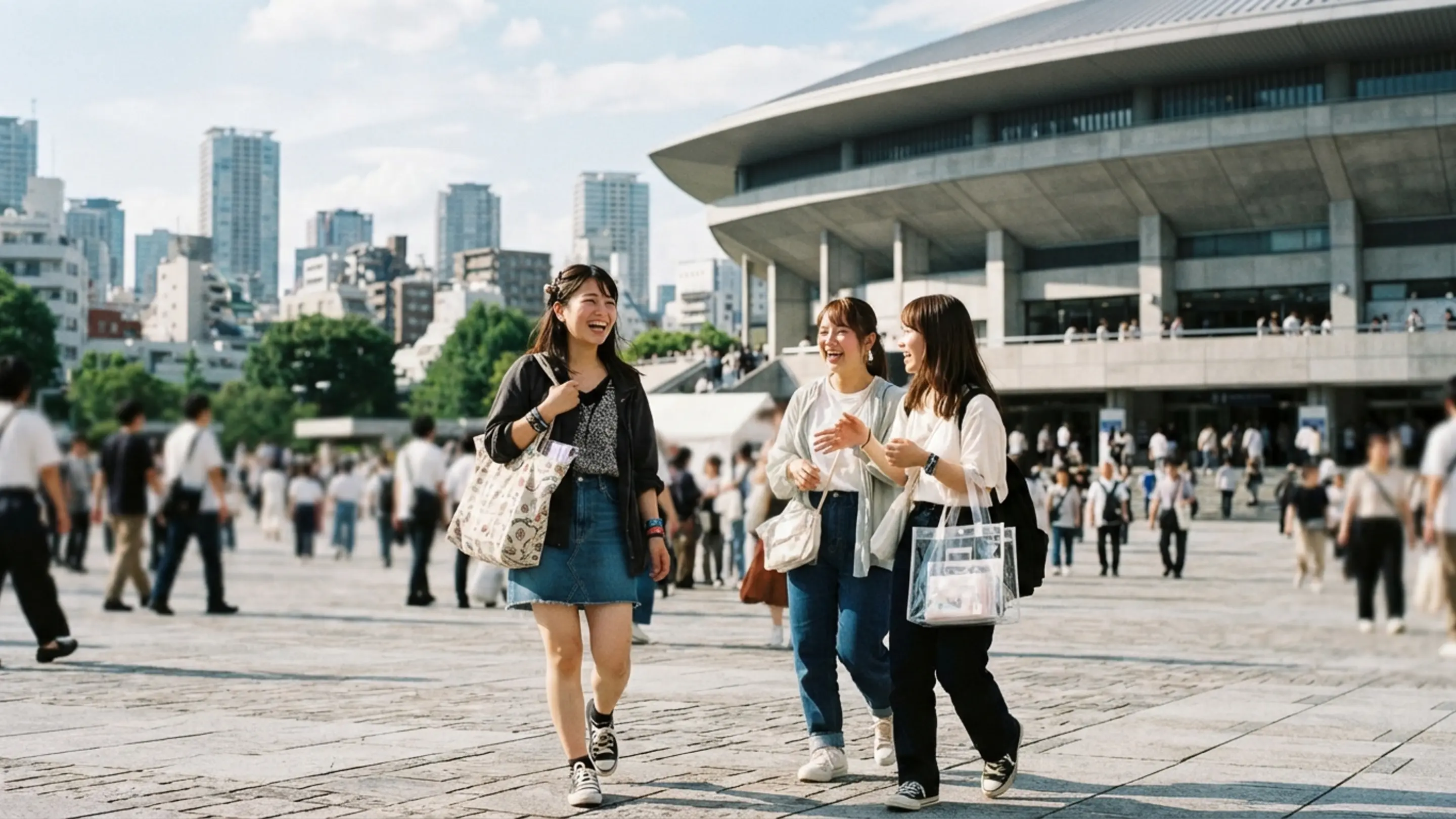 ライブ会場の外でグッズバッグを持って待つファンたちの様子